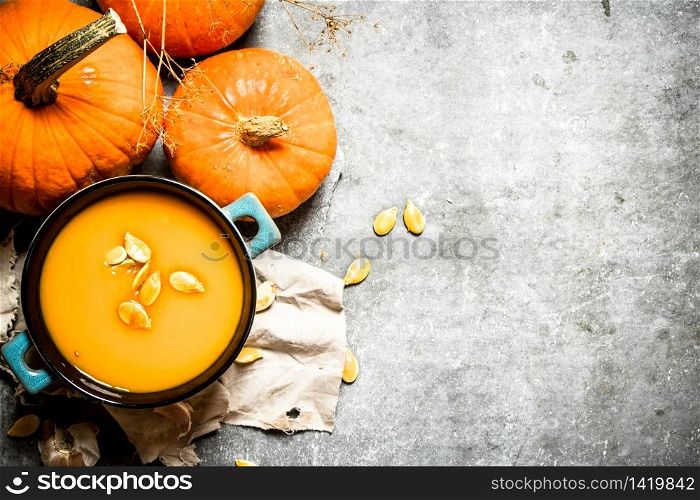 Pumpkin soup from a ripe pumpkin with seeds. On the stone table.. Pumpkin soup