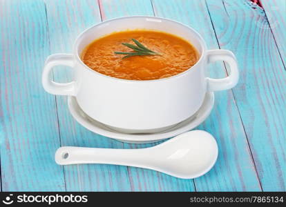 Pumpkin soup in a bowl on a wooden background