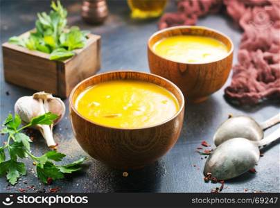 pumpkin soup in bowl and on a table