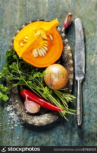 Pumpkin soup ingredients on wooden background close up