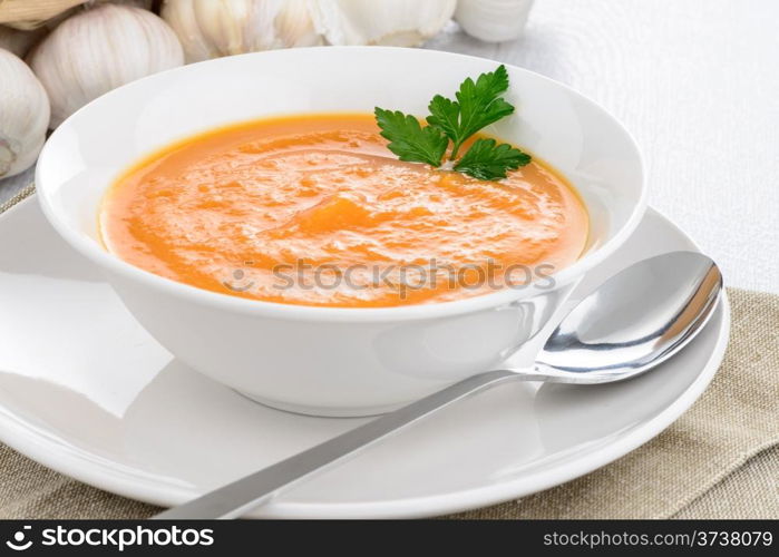 Pumpkin soup on white wood background.