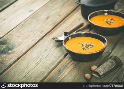 Pumpkin soup on wooden table, space for text. Pumpkin soup on wooden table, cozy food concept