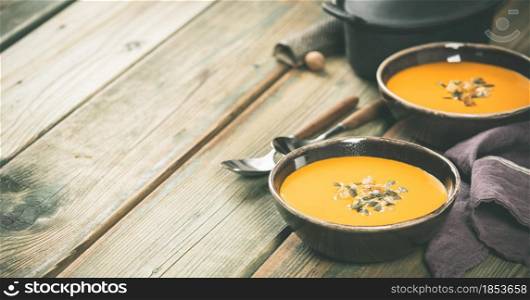 Pumpkin soup on wooden table, space for text. Pumpkin soup on wooden table, copy space