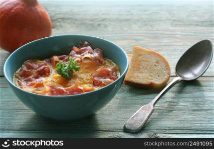 Pumpkin soup served with crispy bacon