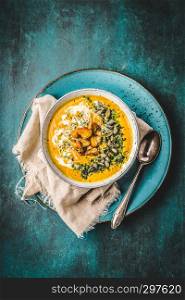 Pumpkin soup with cream,herbs and seeds,top view