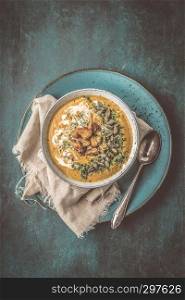 Pumpkin soup with cream,herbs and seeds,top view