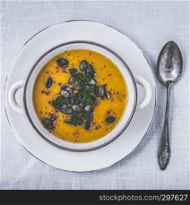 Pumpkin soup with pumpkin seeds, parsley and chili peppers