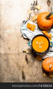 pumpkin soup with seeds on the old fabric. On wooden background.. pumpkin soup with seeds on the old fabric.