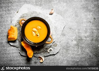 Pumpkin soup with seeds. On the stone table.. Pumpkin soup with seeds.