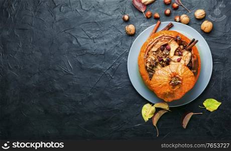 Pumpkin stuffed with granola and dried fruits.Popular autumn dessert.Copy space. Tasty autumn stuffed pumpkin