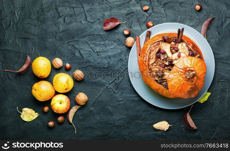 Pumpkin stuffed with granola and dried fruits.Popular autumn dessert.Copy space. Tasty autumn stuffed pumpkin