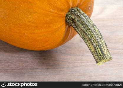 pumpkin with a stem against grained wood