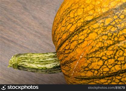 pumpkin with a stem against grained wood with a copy space