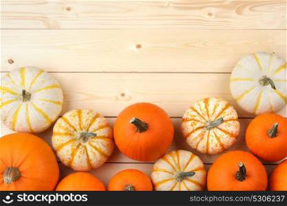 Pumpkins on wooden background. Many orange pumpkins on wooden background, autumn harvest, Halloween or Thanksgiving concept