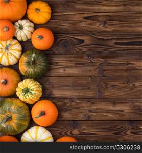 Pumpkins on wooden background. Many orange pumpkins on wooden background, autumn harvest, Halloween or Thanksgiving concept