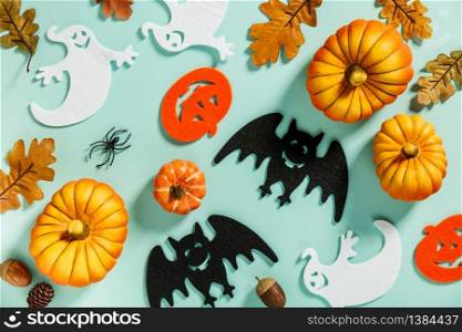 Pumpkins with Halloween decorations on blue background - overhead view flat lay copyspace