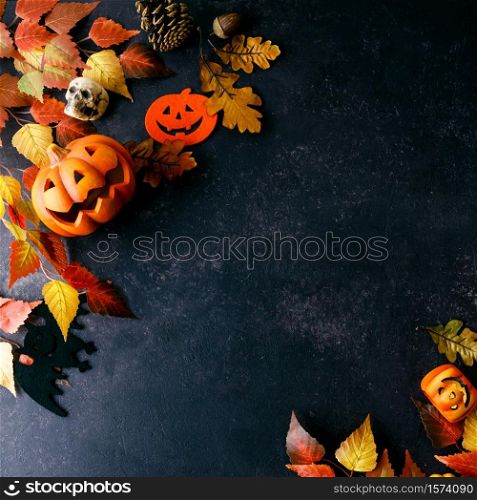 Pumpkins with Halloween decorations on dark background - overhead view flat lay copyspace