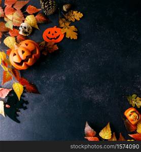 Pumpkins with Halloween decorations on dark background - overhead view flat lay copyspace