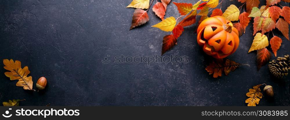 Pumpkins with Halloween decorations on dark background - overhead view flat lay copyspace