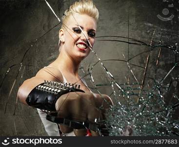 Punk girl breaking glass with a brass knuckles