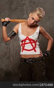 Punk girl with a baseball bat against grey background.
