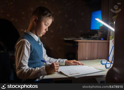 pupil boy does his homework. The pupil boy does his homework