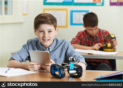 Pupil Controlling Robot With Digital Tablet In Science Lesson