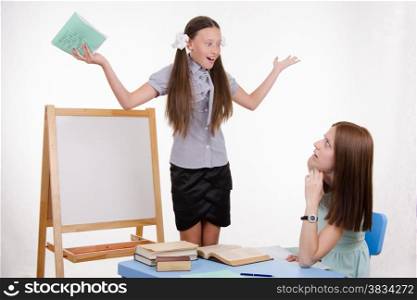 Pupil stands at the blackboard, the teacher sits at his desk and listens to the student