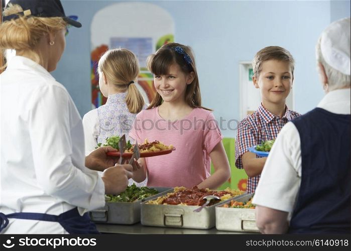 Pupils Being Served With Healthy Lunch In School Canteen