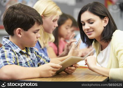 Pupils In Class Using Digital Tablet With Teacher