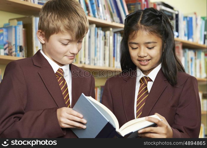 Pupils Wearing School Uniform Reading Book In Library