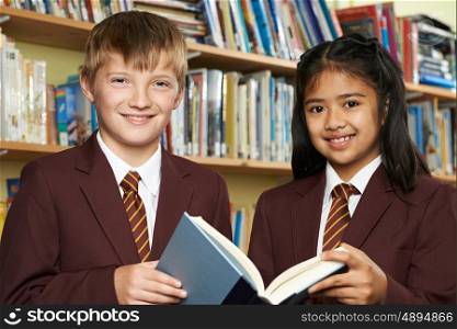 Pupils Wearing School Uniform Reading Book In Library