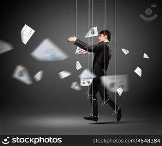 Puppet businessman. Image of businessman hanging on strings like marionette. Conceptual photography