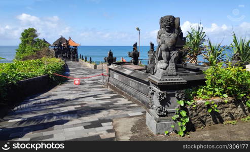 Pura Batu Bolong on the edge of a cliff at coastline with hole in the rock in Bali, Indonesia