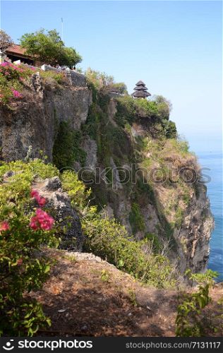 Pura Luhur Uluwatu temple in Bali, Indonesia with cliff with blue sky and sea
