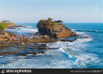 Pura Tanah Lot, the water temple, in Bali at noon. It is one of the most popular of tourist attraction. Indonesia. Nature landscape background of travel trip and holidays vacation in Indonesia.