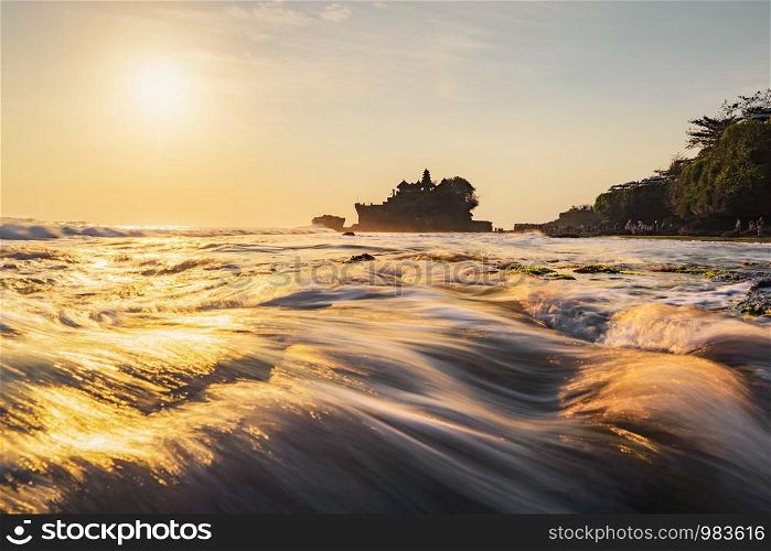 Pura Tanah Lot, the water temple, in Bali at sunset. It is one of the most popular of tourist attraction. Indonesia. Nature landscape background of travel trip and holidays vacation in Indonesia.