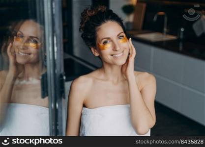 Pure skin after shower and spa. Attractive caucasian lady wrapped in towel after bathing is happy and relaxing at home or hotel room. Spa resort, body care. Having rest on weekend or vacation concept.. Attractive caucasian lady wrapped in towel after bathing is relaxing at home or hotel room.