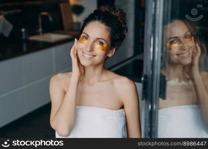 Pure skin after shower and spa. Attractive caucasian lady wrapped in towel after bathing is happy and relaxing at home or hotel room. Spa resort, body care. Having rest on weekend or vacation concept.. Attractive caucasian lady wrapped in towel after bathing is relaxing at home or hotel room.