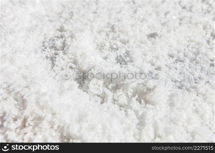 Pure white crystals salt, rock salt on the ground. Top view, close. Traditional rock salt making of Bo Kluea, Nan, Thailand. Ancient salt pits. Salt culture. History of salt. Full frame. Bright sunlight.