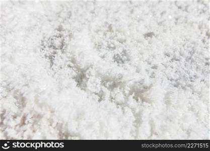 Pure white crystals salt, rock salt on the ground. Top view, close. Traditional rock salt making of Bo Kluea, Nan, Thailand. Ancient salt pits. Salt culture. History of salt. Full frame. Bright sunlight.
