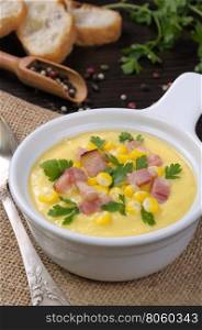 Puree soup of corn with slices of fried bacon with parsley
