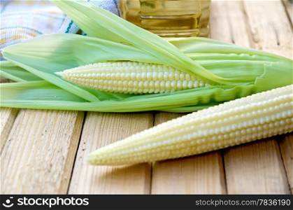 Purified corn cobs, cloth, oil in a bottle on the background of wooden boards
