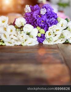 Purple and white contrasting flowers placed on wooden surface.. Purple and white flowers on wooden surface