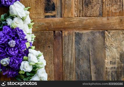 Purple and white contrasting flowers placed on wooden surface.