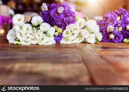 Purple and white flowers on wooden surface