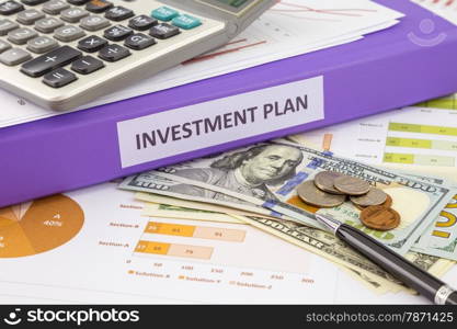 Purple binder of investment plan place on money and financial graphs reports, concept for saving fund and budget management