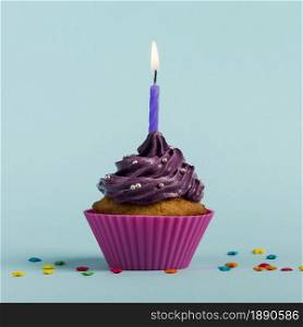purple burning candles decorative muffins with colorful star sprinkles against blue backdrop . Resolution and high quality beautiful photo. purple burning candles decorative muffins with colorful star sprinkles against blue backdrop . High quality and resolution beautiful photo concept
