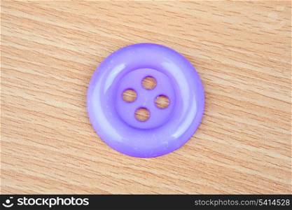 Purple button with four holes on a white background