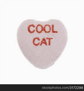 Purple candy heart that reads cool cat against white background.